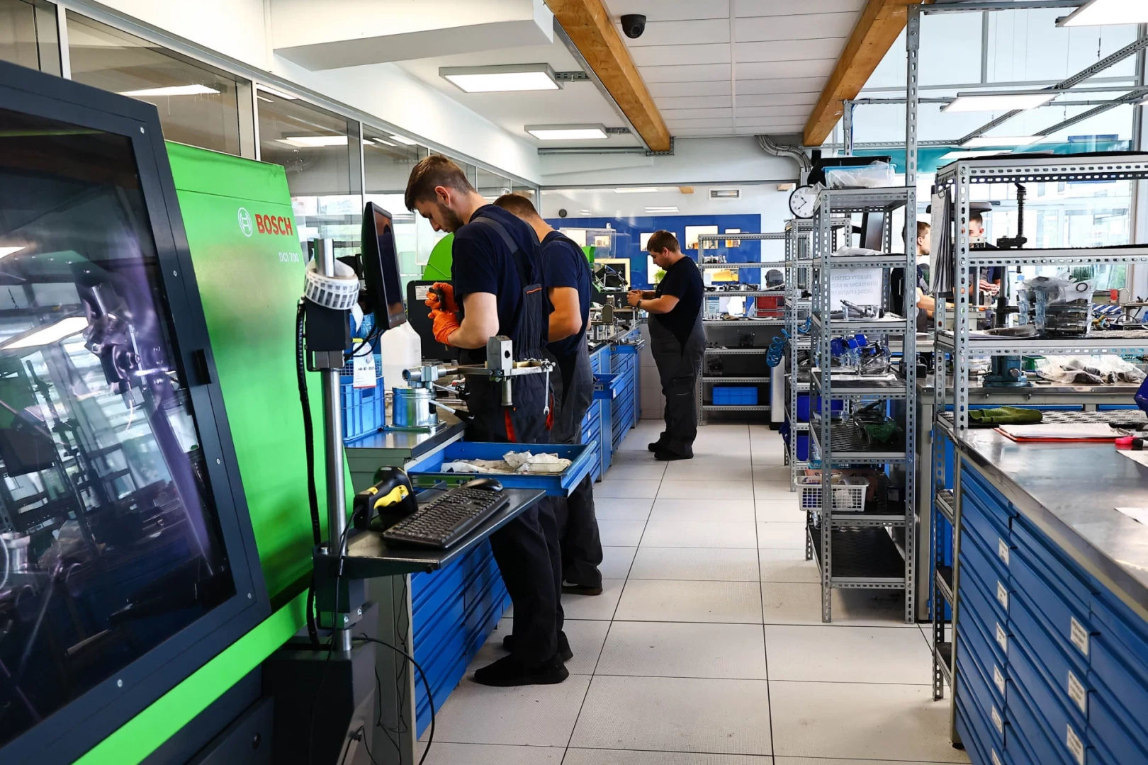Profesjonalne zaplecze do obsługi wtryskiwaczy Technicy pracujący przy specjalistycznych urządzeniach i stanowiskach roboczych w nowoczesnym warsztacie.