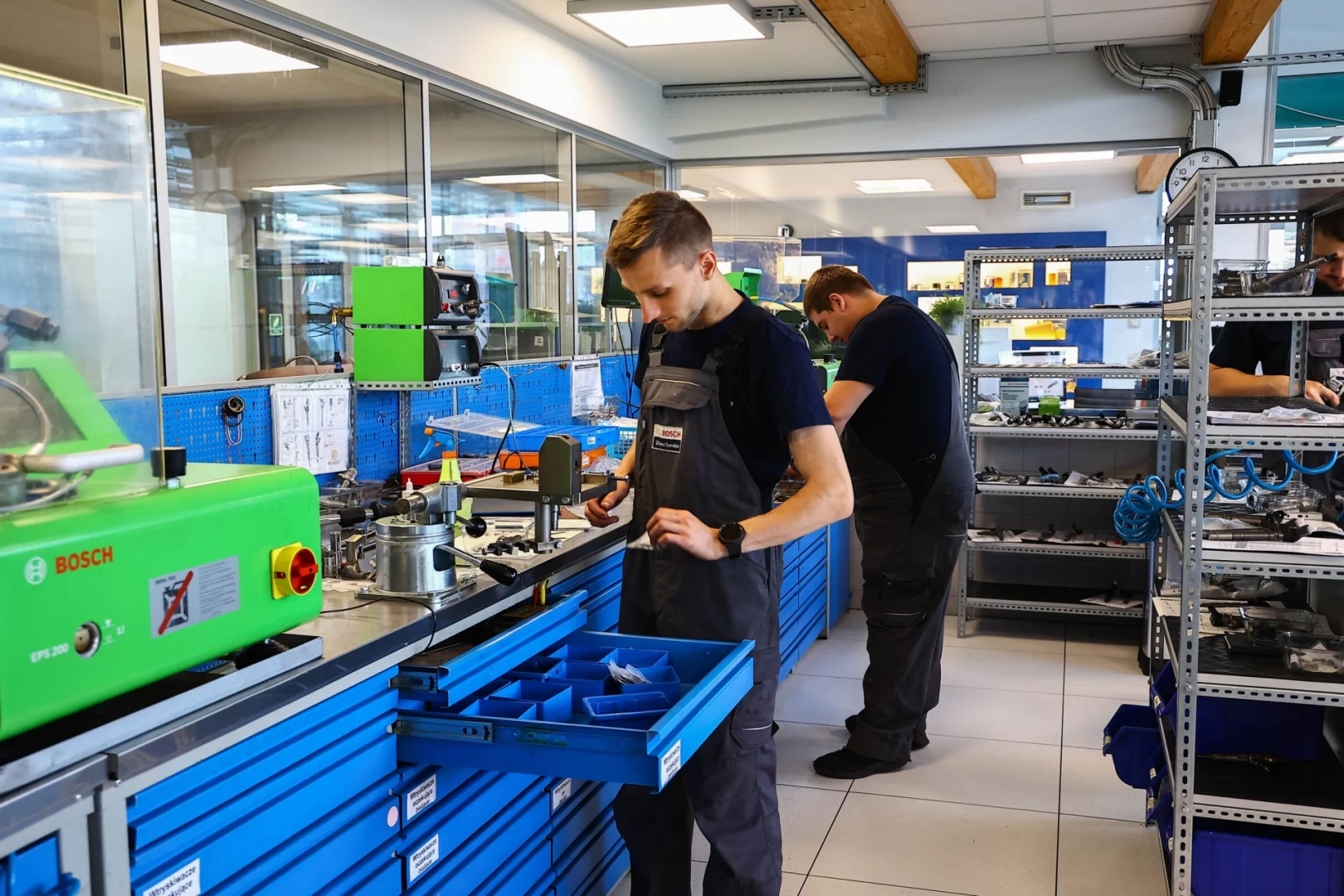 Pracownicy przy stanowiskach roboczych w wyposażonym warsztacie