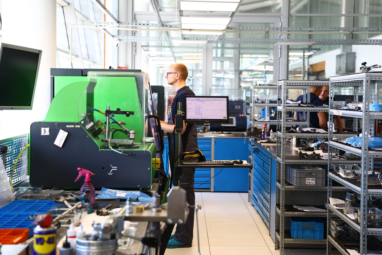 Technik wykonujący diagnostykę wtryskiwaczy benzynowych na specjalistycznym stanowisku testowym