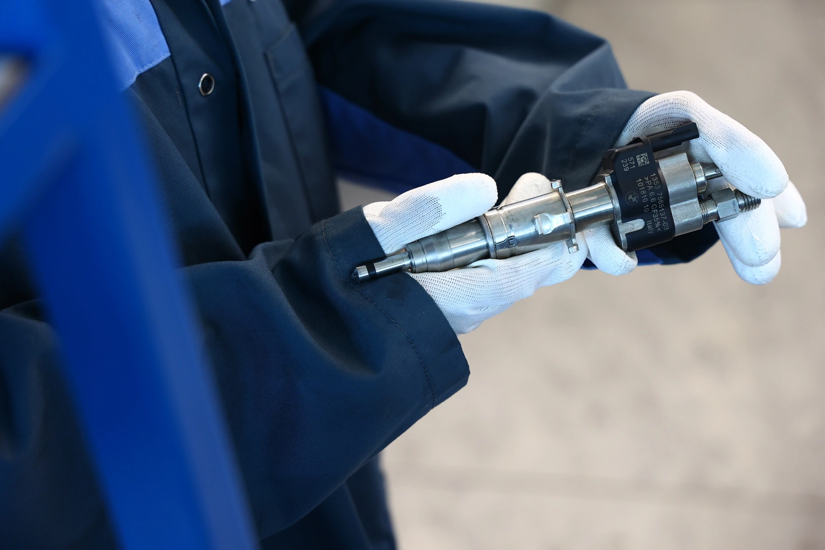 Technik trzymający wtryskiwacz Common Rail podczas kontroli w pracowni regeneracji