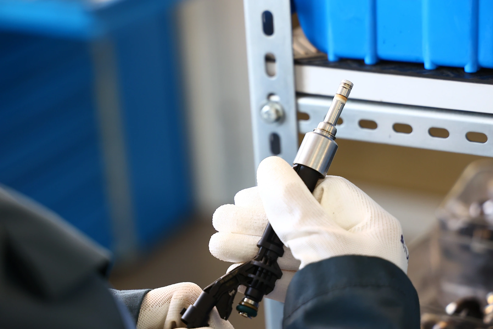 Kontrola wtryskiwacza benzynowego przed testem stanowiskowym Technik trzymający wtryskiwacz benzynowy podczas przygotowania do diagnostyki i pomiaru parametrów pracy