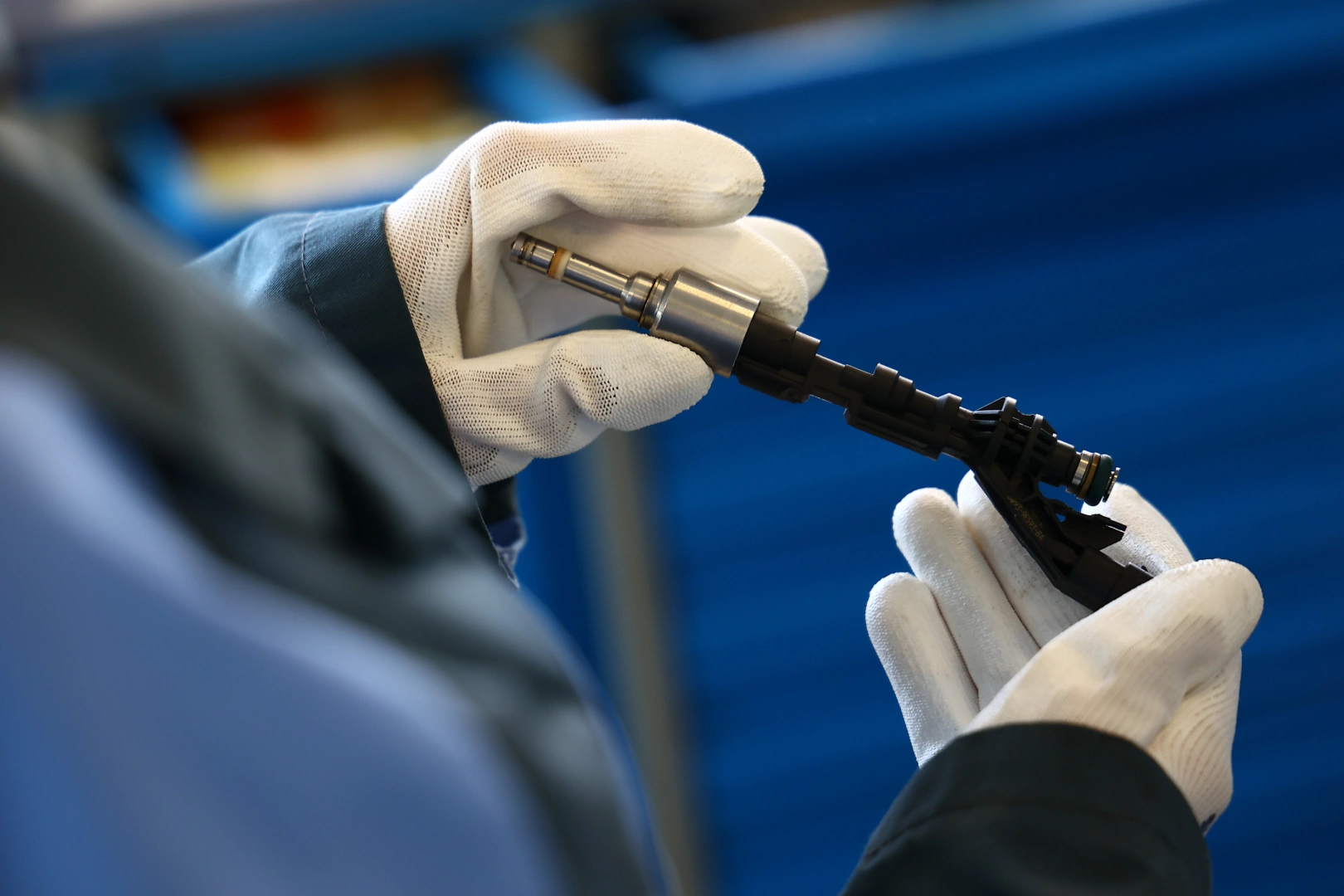 Kontrola wtryskiwacza przed wykonaniem testu Technik w białych rękawicach oglądający metalowo-plastikowy wtryskiwacz