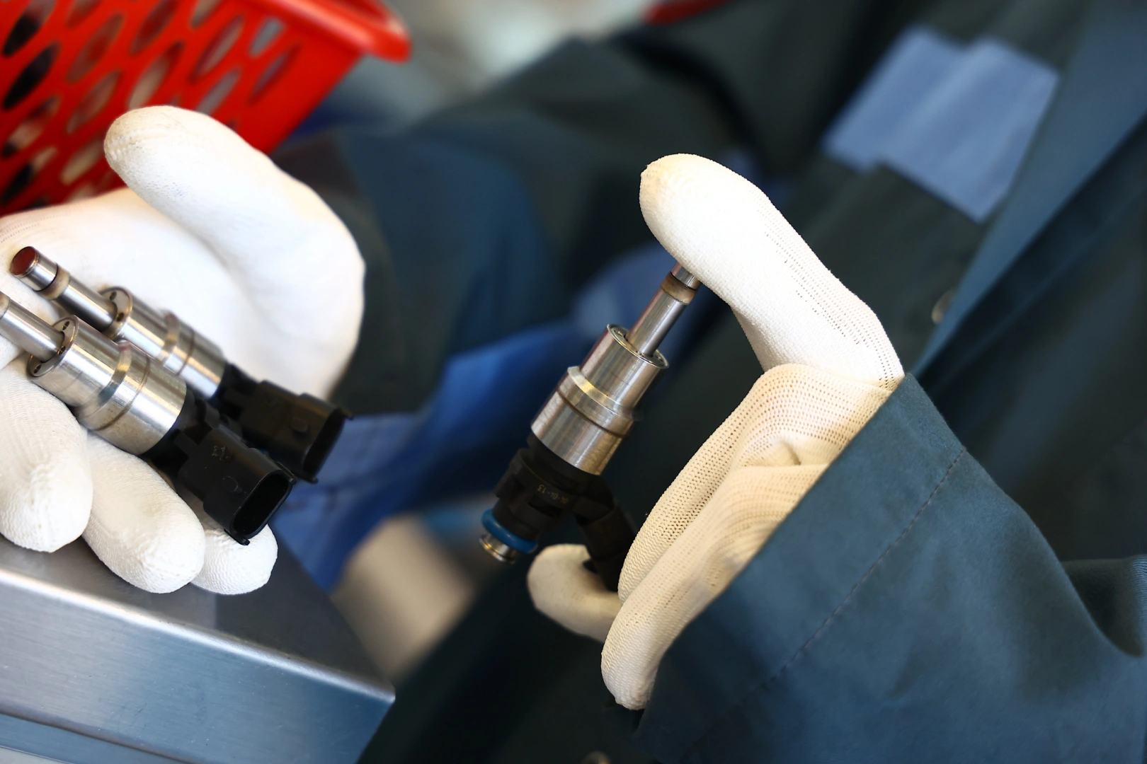 Kontrola wtryskiwaczy benzynowych przed diagnostyką Technik porównujący wtryskiwacze benzynowe podczas oględzin przed testem stanowiskowym