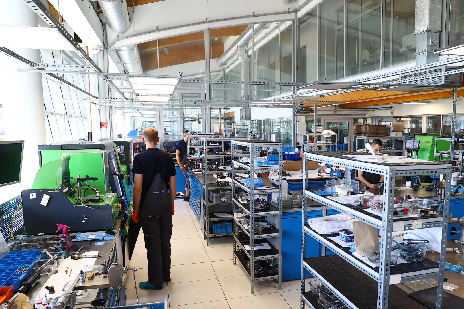 Nowoczesne zaplecze produkcyjne i serwisowe Pracownicy przy stanowiskach montażowych i serwisowych w nowoczesnej hali technicznej.