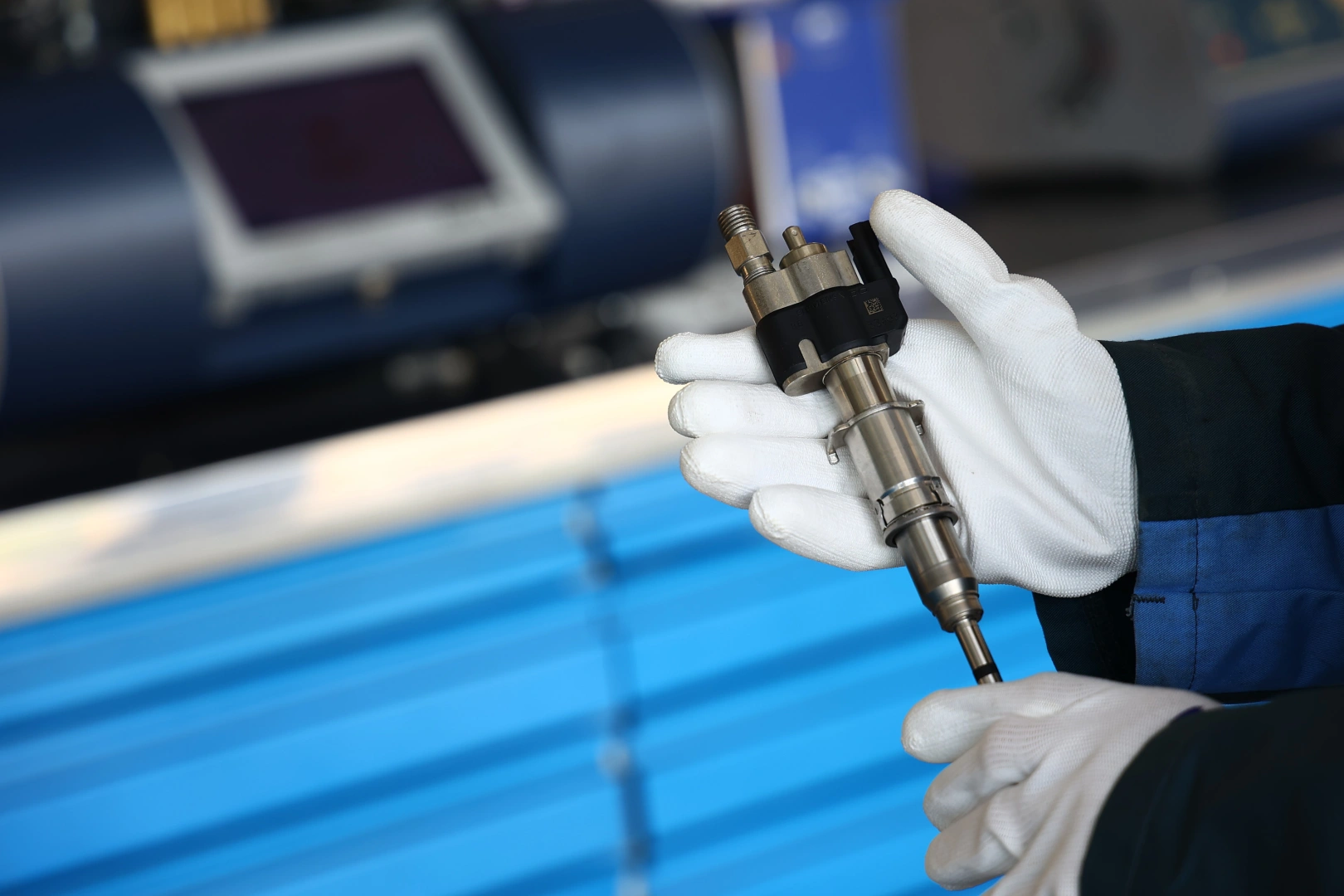 Oględziny wtryskiwacza przed badaniem parametrów Wtryskiwacz trzymany w białych rękawicach podczas kontroli przed testem