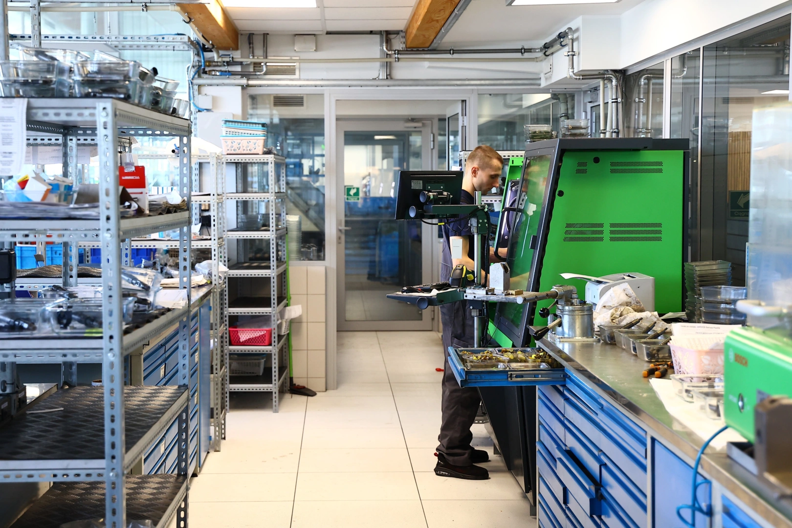 Technik pracujący przy stanowisku diagnostycznym w pracowni wtryskiwaczy benzynowych