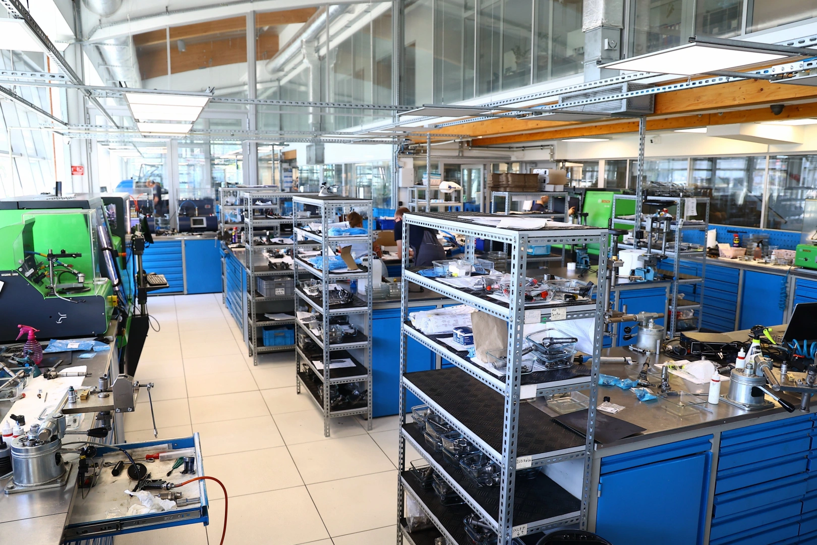 Pracownia wtryskiwaczy benzynowych – stanowiska techników Specjalistyczna pracownia wtryskiwaczy benzynowych z wyposażonymi stanowiskami roboczymi, przy których pracują technicy.