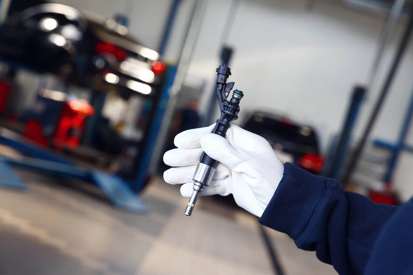 Technik prezentujący wtryskiwacz benzynowy w serwisie układów wtryskowych