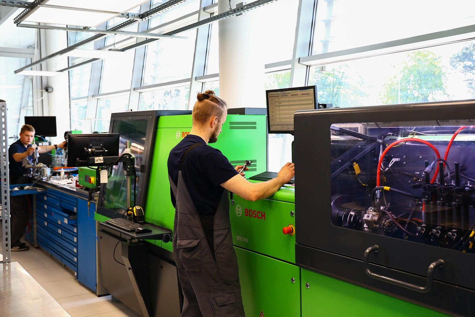 Profesjonalne testy wtryskiwaczy na stanowisku Bosch Technik testujący wtryskiwacz na specjalistycznym stanowisku Bosch w pracowni regeneracji.