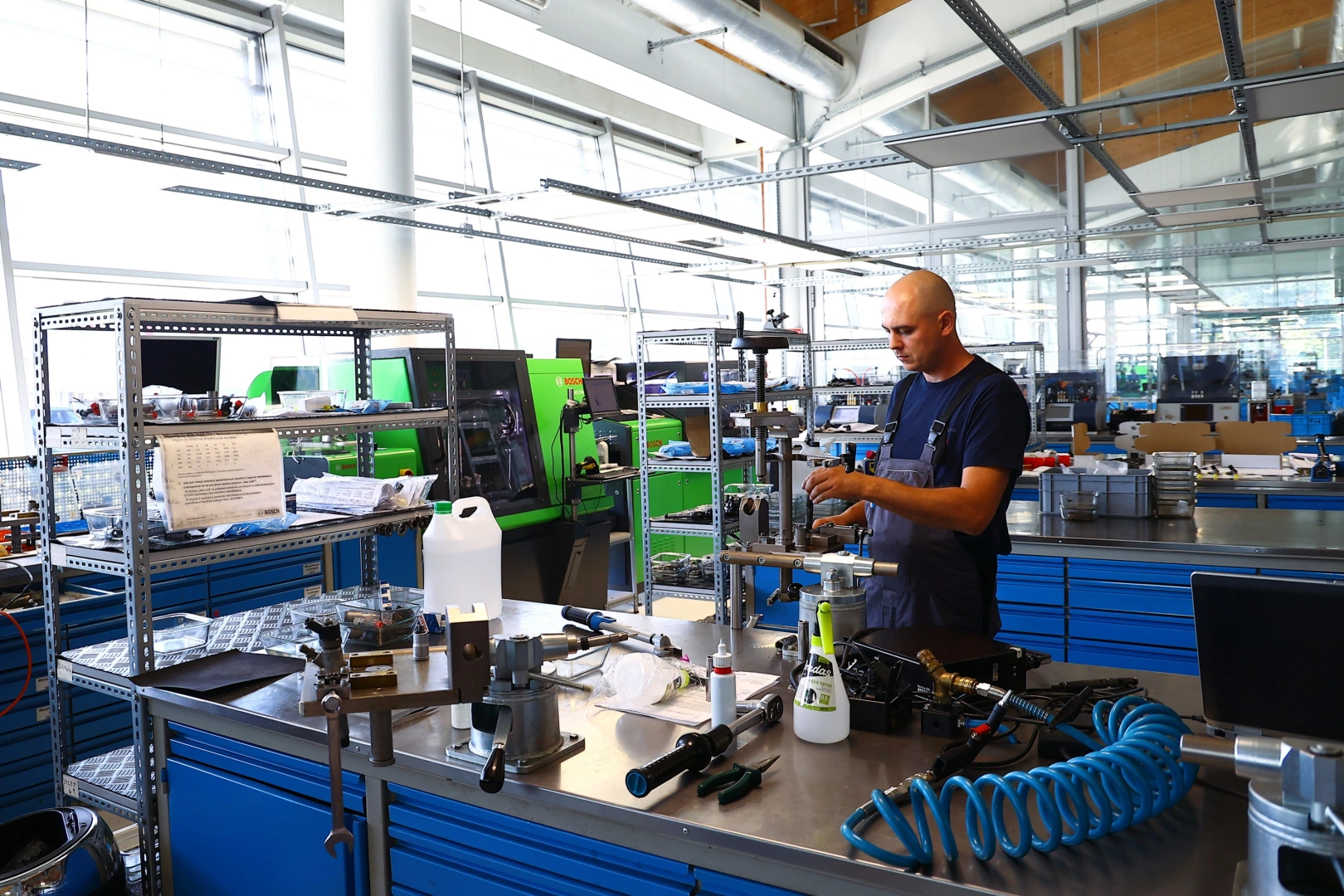 Technik pracujący przy stanowisku do regeneracji wtryskiwaczy w specjalistycznej pracowni