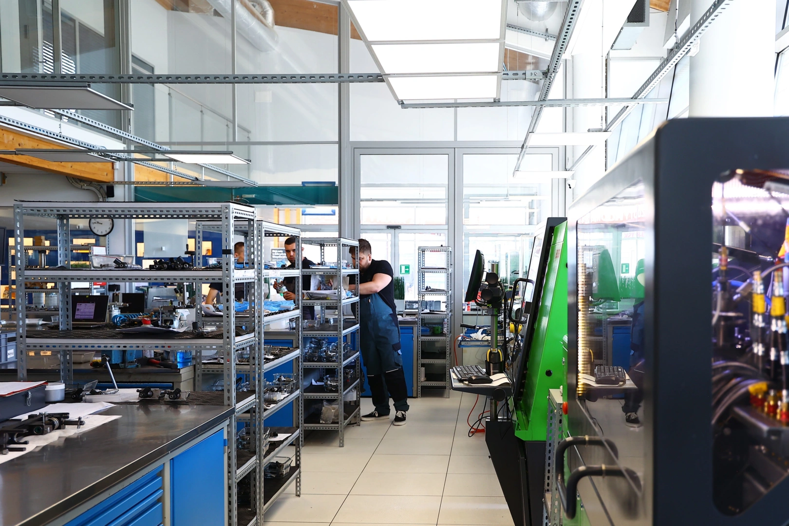 Technicy pracujący przy specjalistycznych stanowiskach i urządzeniach do obsługi wtryskiwaczy benzynowych. Technicy pracujący przy specjalistycznych stanowiskach i urządzeniach do obsługi wtryskiwaczy benzynowych.