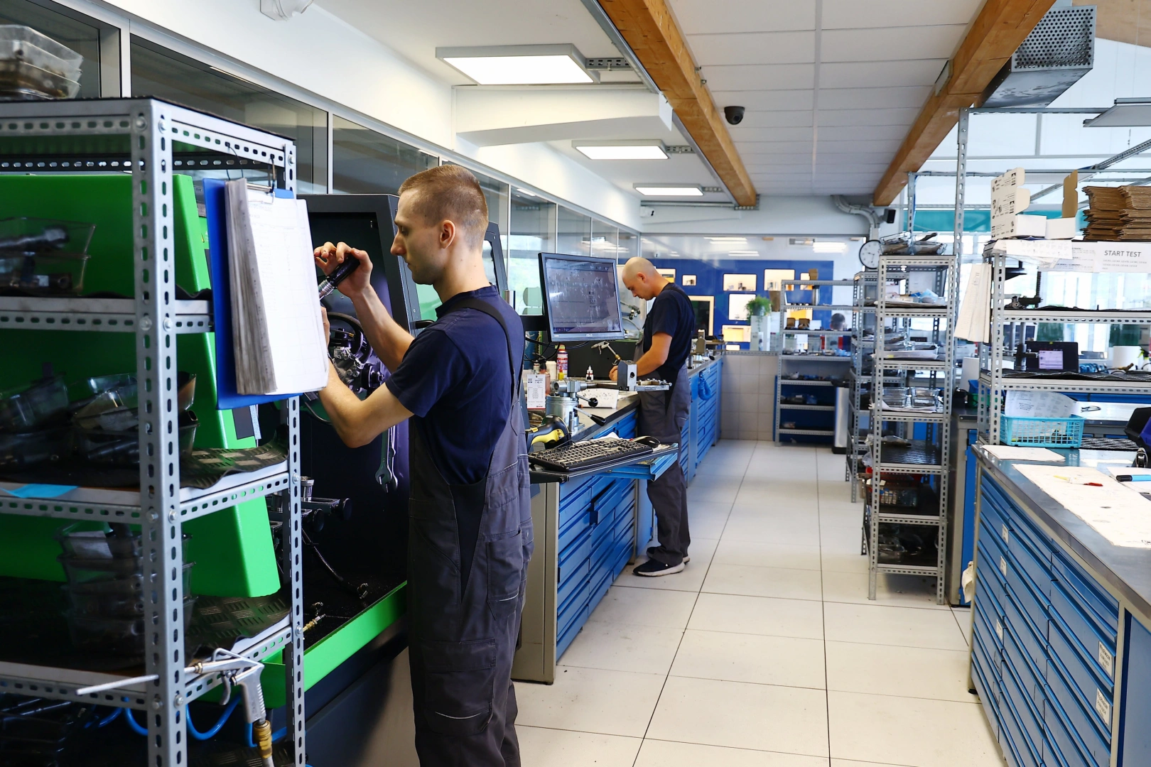 Technik podczas diagnostyki wtryskiwaczy benzynowych Technik przygotowujący wtryskiwacz do badania na stanowisku diagnostycznym w pracowni
