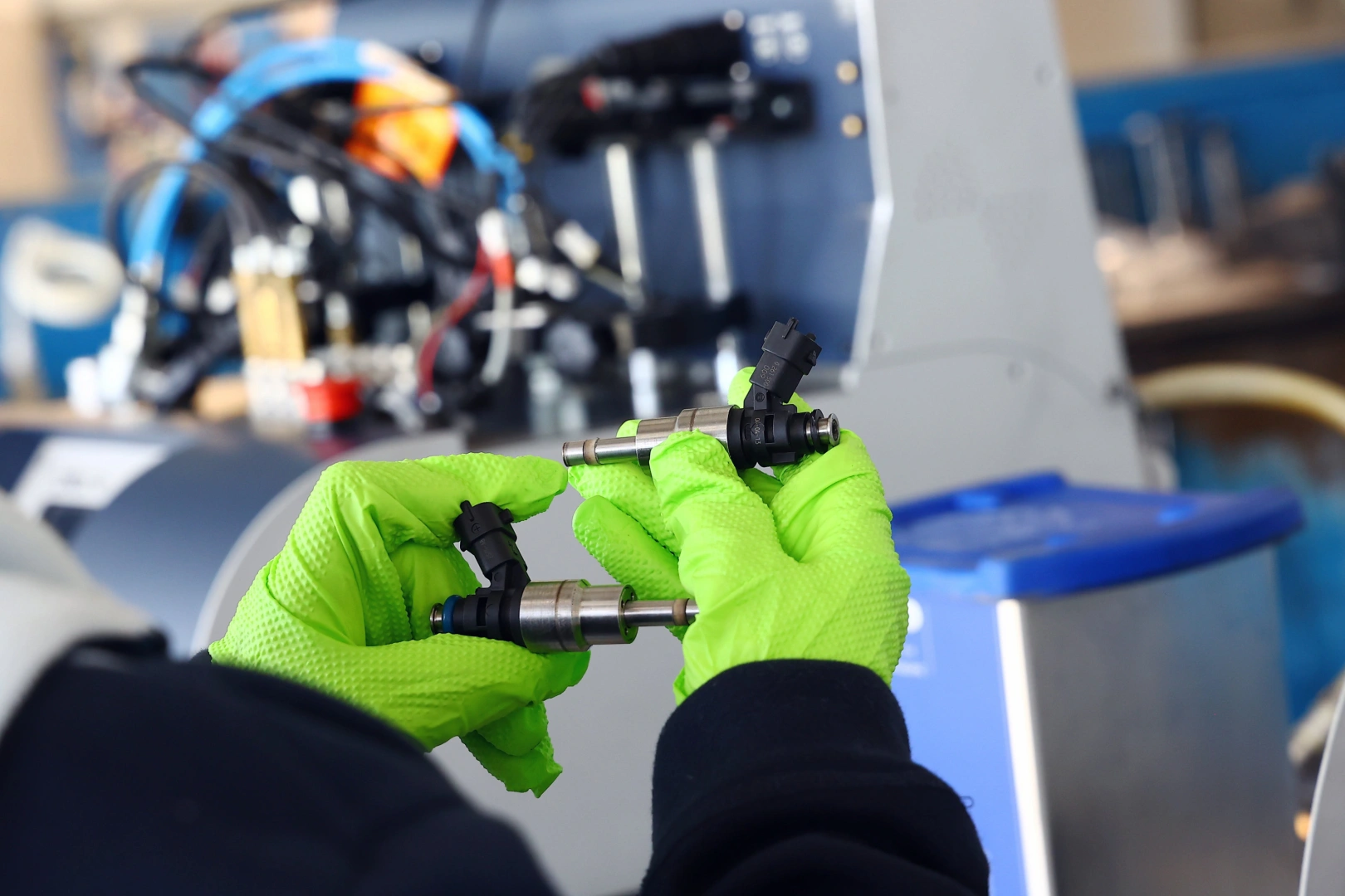 Technik porównujący dwa wtryskiwacze benzynowe GDI przed montażem na stanowisku do diagnostyki parametrów pracy Technik porównujący dwa wtryskiwacze benzynowe GDI przed montażem na stanowisku do diagnostyki parametrów pracy