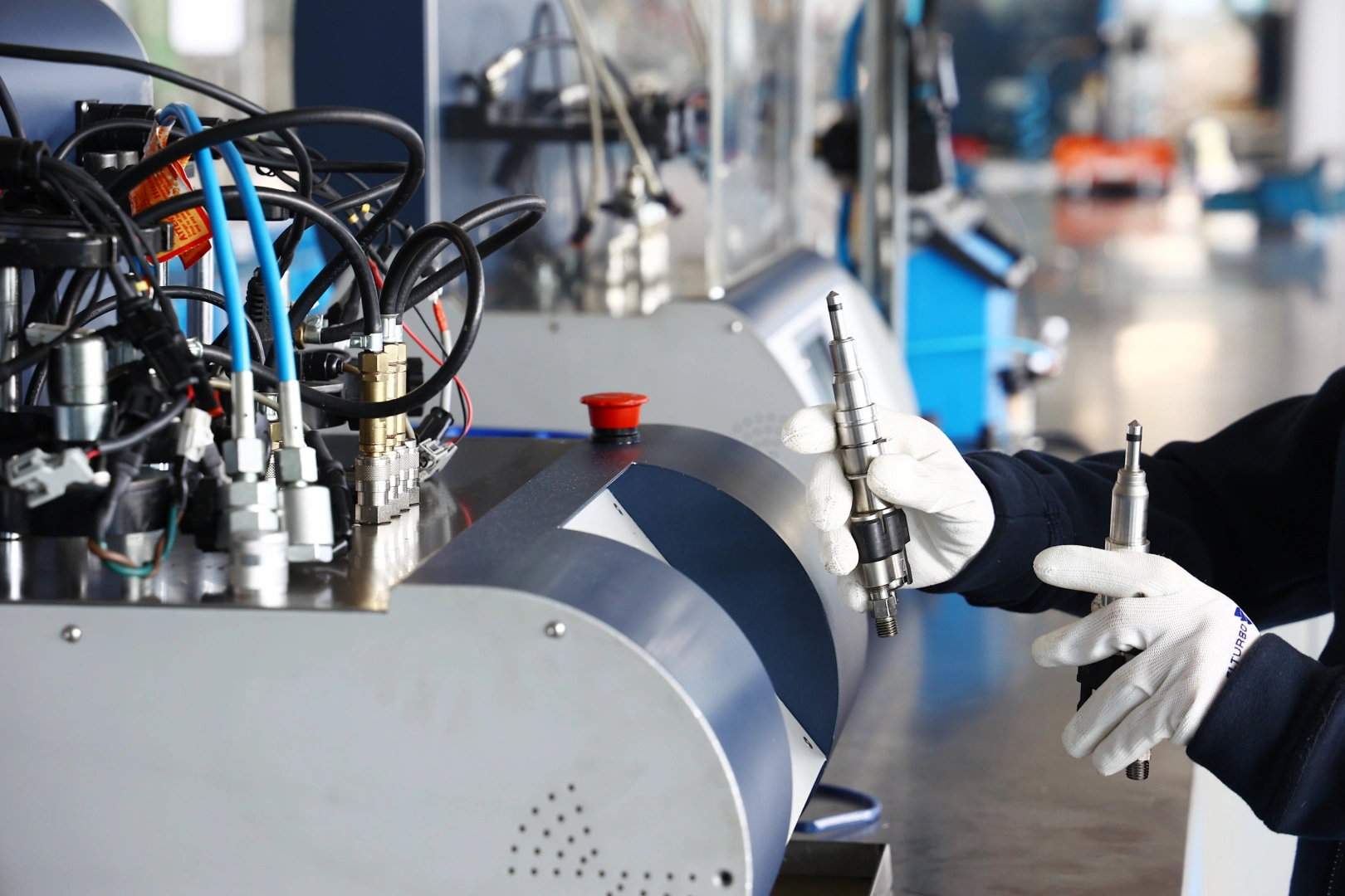 Technik porównujący dwa wtryskiwacze benzynowe przed montażem i diagnostyką na specjalistycznym stanowisku probierczym Technik porównujący dwa wtryskiwacze benzynowe przed montażem i diagnostyką na specjalistycznym stanowisku probierczym