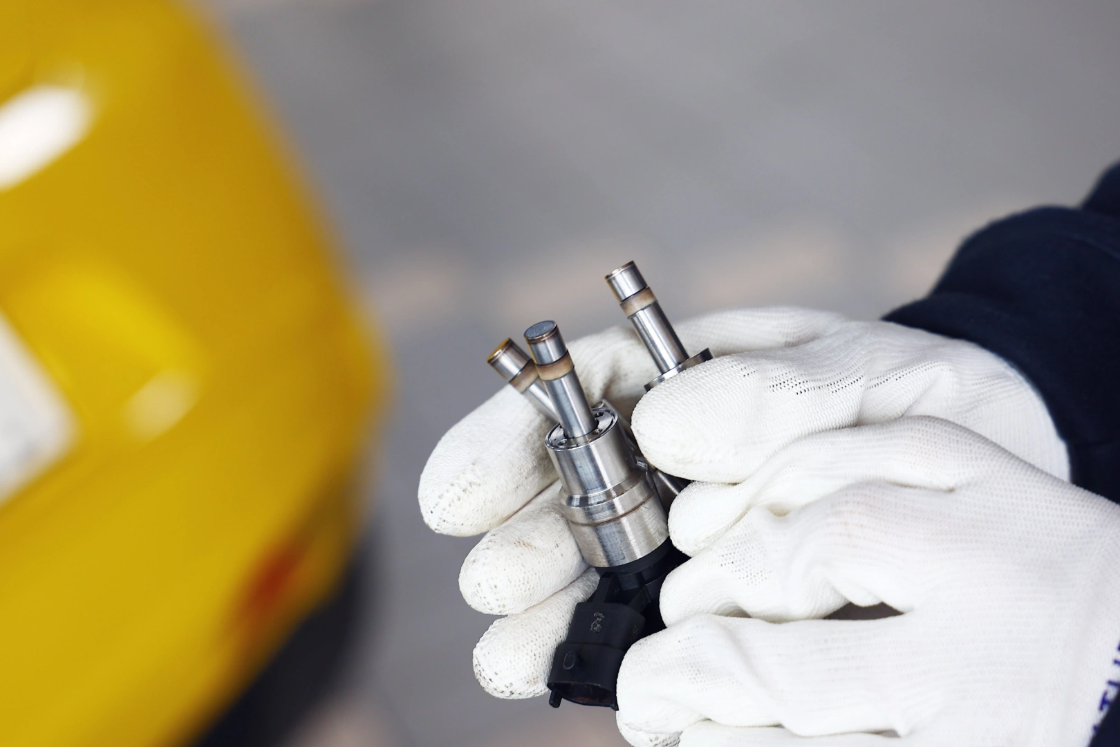 Technik porównuje końcówki kilku wtryskiwaczy benzynowych, sprawdzając stan strefy rozpylającej przed dalszą diagnostyką parametrów pracy. Technik porównuje końcówki kilku wtryskiwaczy benzynowych, sprawdzając stan strefy rozpylającej przed dalszą diagnostyką parametrów pracy.