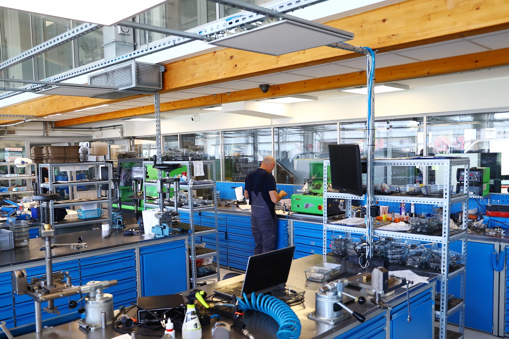 Technik przy stanowisku regeneracji wtryskiwaczy benzynowych Technik pracujący przy specjalistycznym stanowisku do diagnostyki i regeneracji wtryskiwaczy benzynowych w nowoczesnej pracowni.