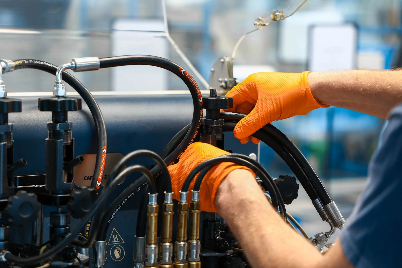 Technik regulujący uchwyt i przewody stanowiska przeznaczonego do testów wtryskiwaczy benzynowych. Technik regulujący uchwyt i przewody stanowiska przeznaczonego do testów wtryskiwaczy benzynowych.
