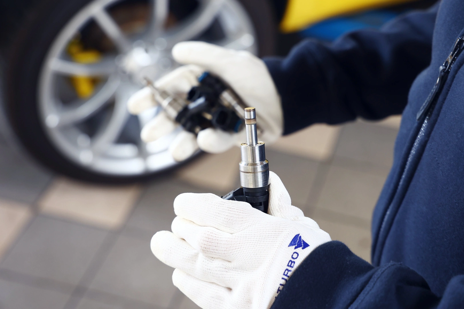 Technik sprawdza końcówkę wtryskiwacza benzynowego GDI przed wykonaniem testów szczelności, dawkowania i jakości rozpylania. Technik sprawdza końcówkę wtryskiwacza benzynowego GDI przed wykonaniem testów szczelności, dawkowania i jakości rozpylania.