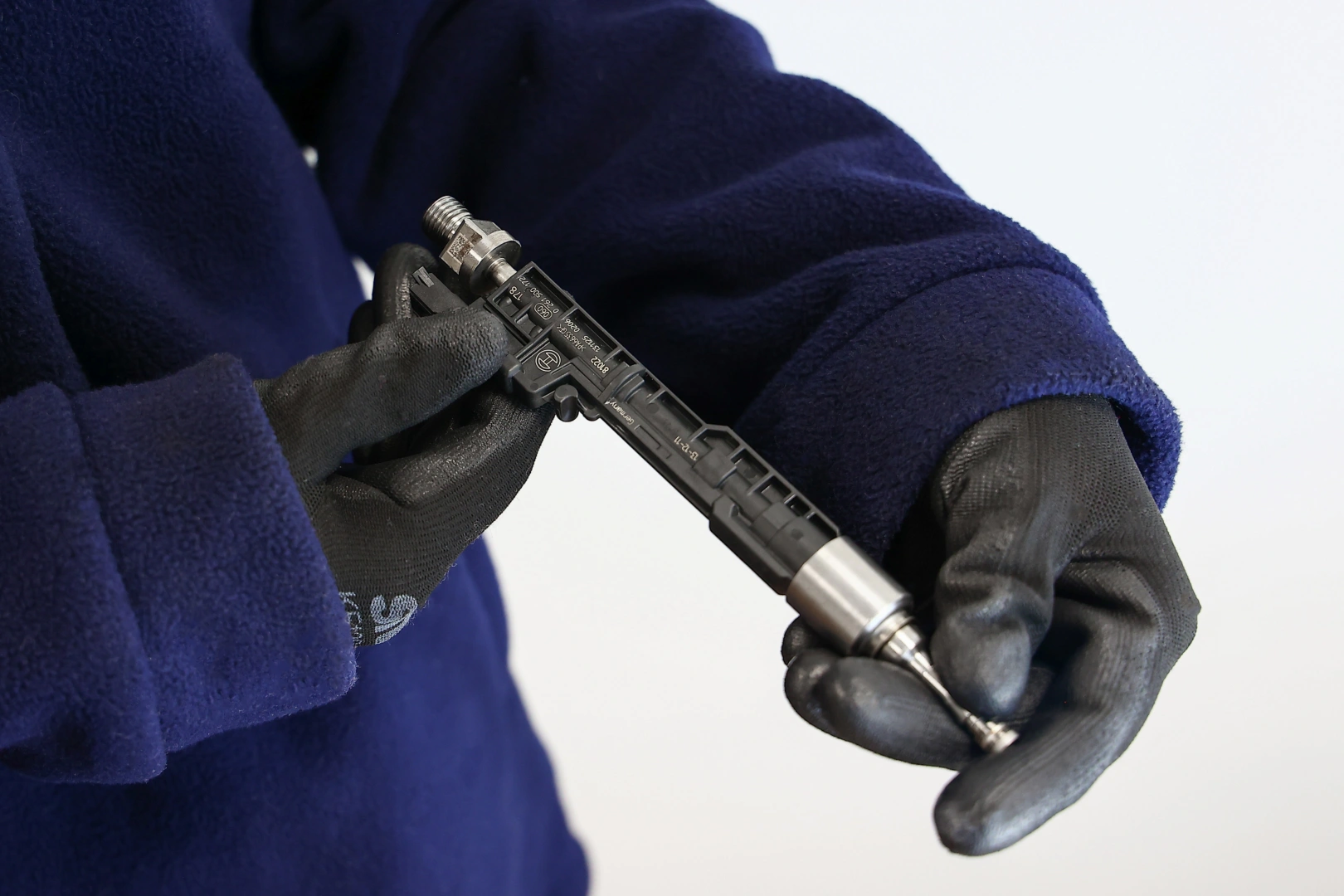 Technik sprawdza stan wtryskiwacza benzynowego przed dalszą diagnostyką Technik sprawdza stan wtryskiwacza benzynowego przed dalszą diagnostyką