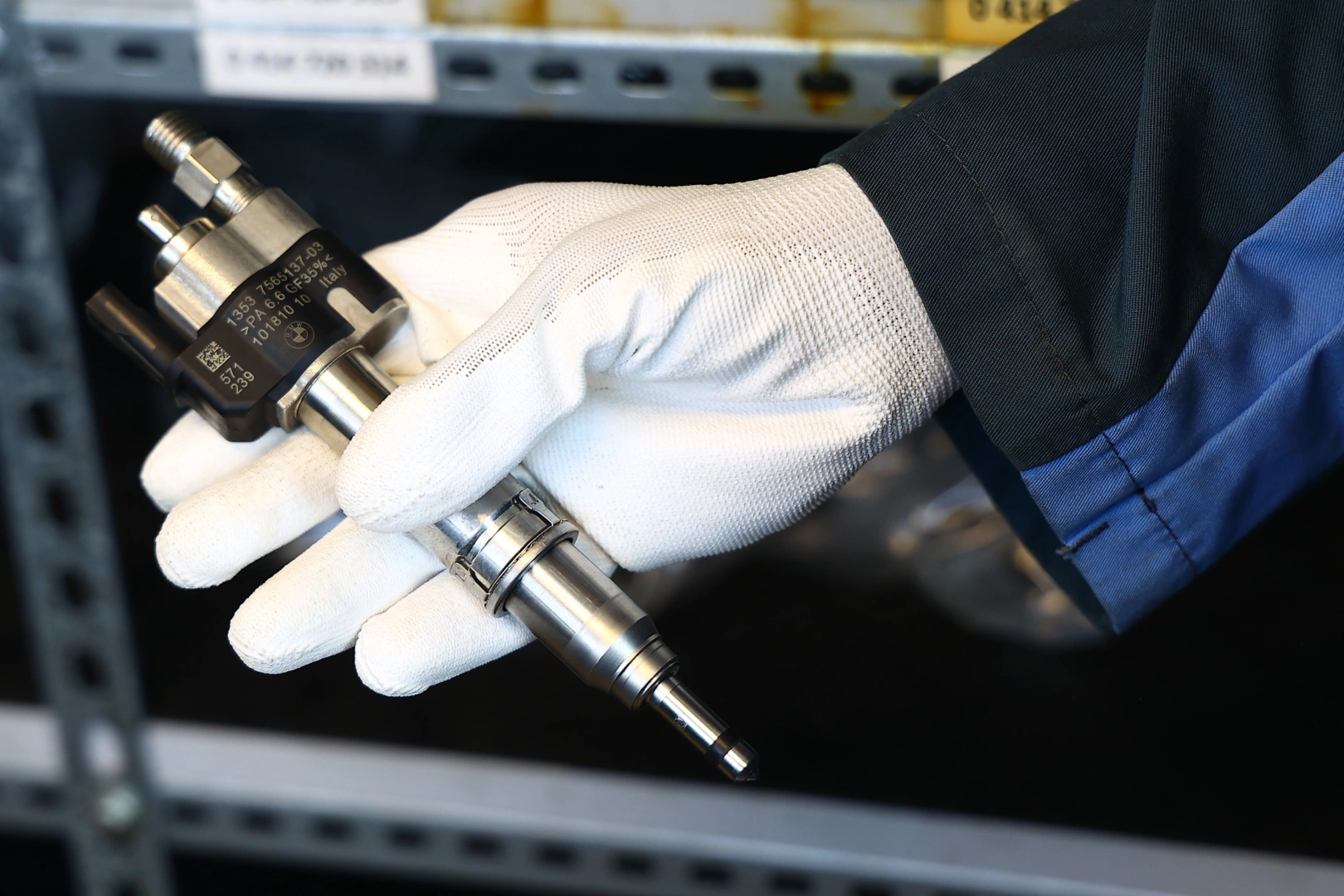 Technik trzyma wtryskiwacz paliwa podczas kontroli w warsztacie Technik trzyma wtryskiwacz paliwa podczas kontroli w warsztacie