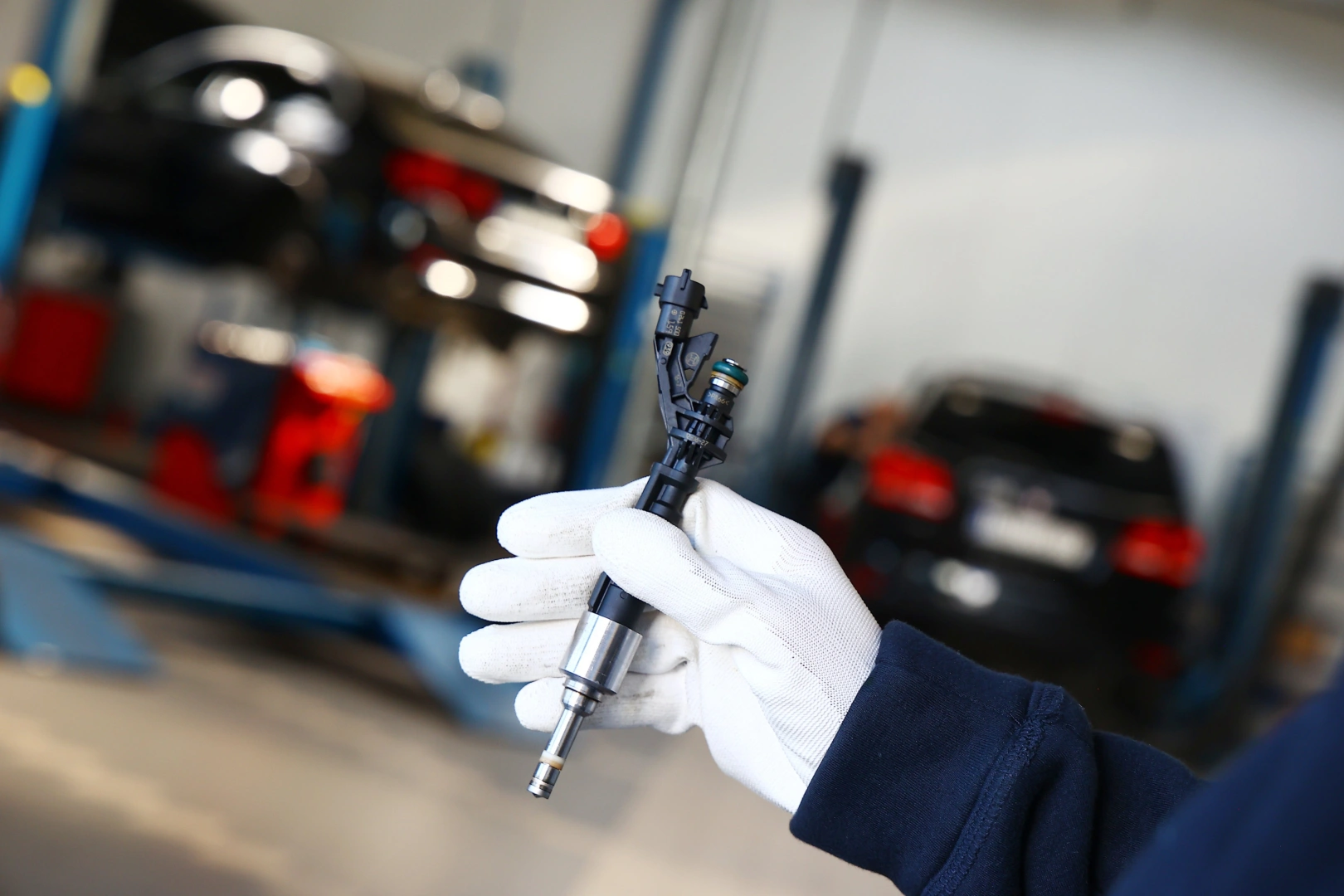 Technik trzymający wtryskiwacz benzynowy GDI podczas oceny korpusu, złączy i końcówki przed diagnostyką stanowiskową Technik trzymający wtryskiwacz benzynowy GDI podczas oceny korpusu, złączy i końcówki przed diagnostyką stanowiskową