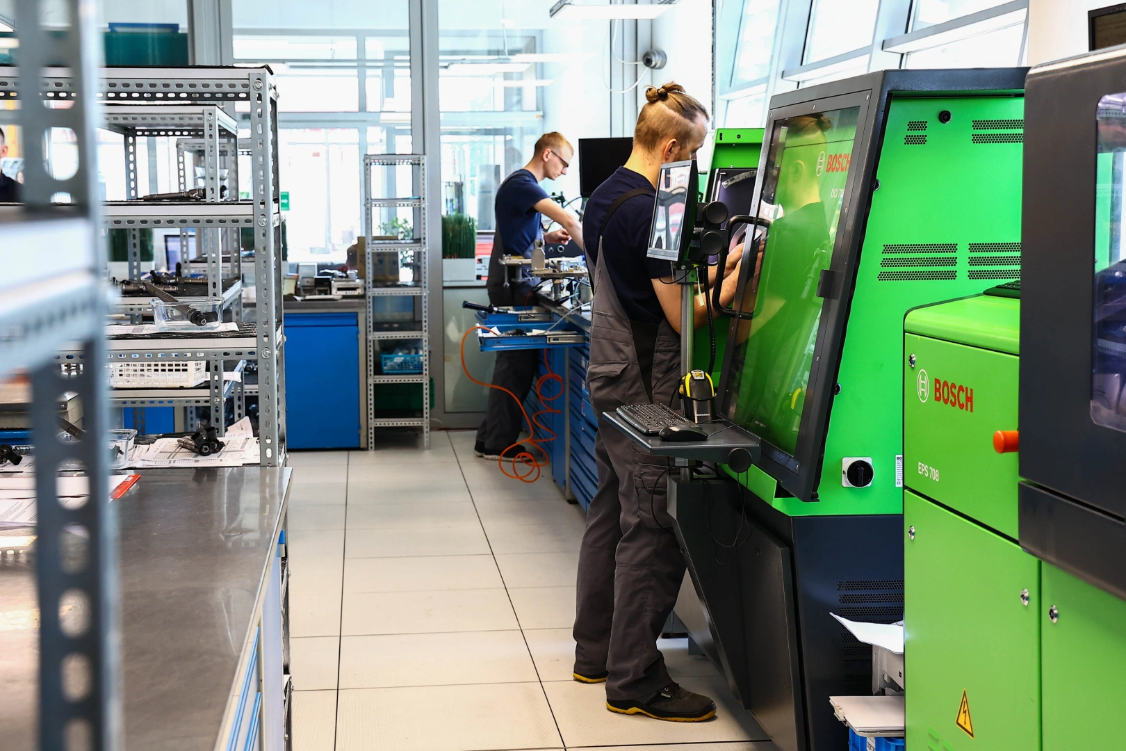 Testowanie wtryskiwaczy na stanowisku diagnostycznym Technik obsługujący zielone urządzenie probiercze w pracowni układów wtryskowych