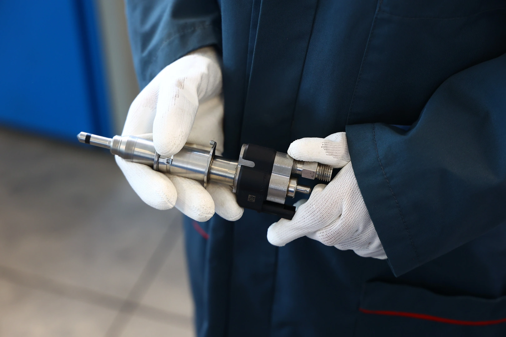 Wtryskiwacz benzynowy Siemens VDO trzymany przez pracownika podczas kontroli stanu podzespołu Wtryskiwacz benzynowy Siemens VDO trzymany przez pracownika podczas kontroli stanu podzespołu