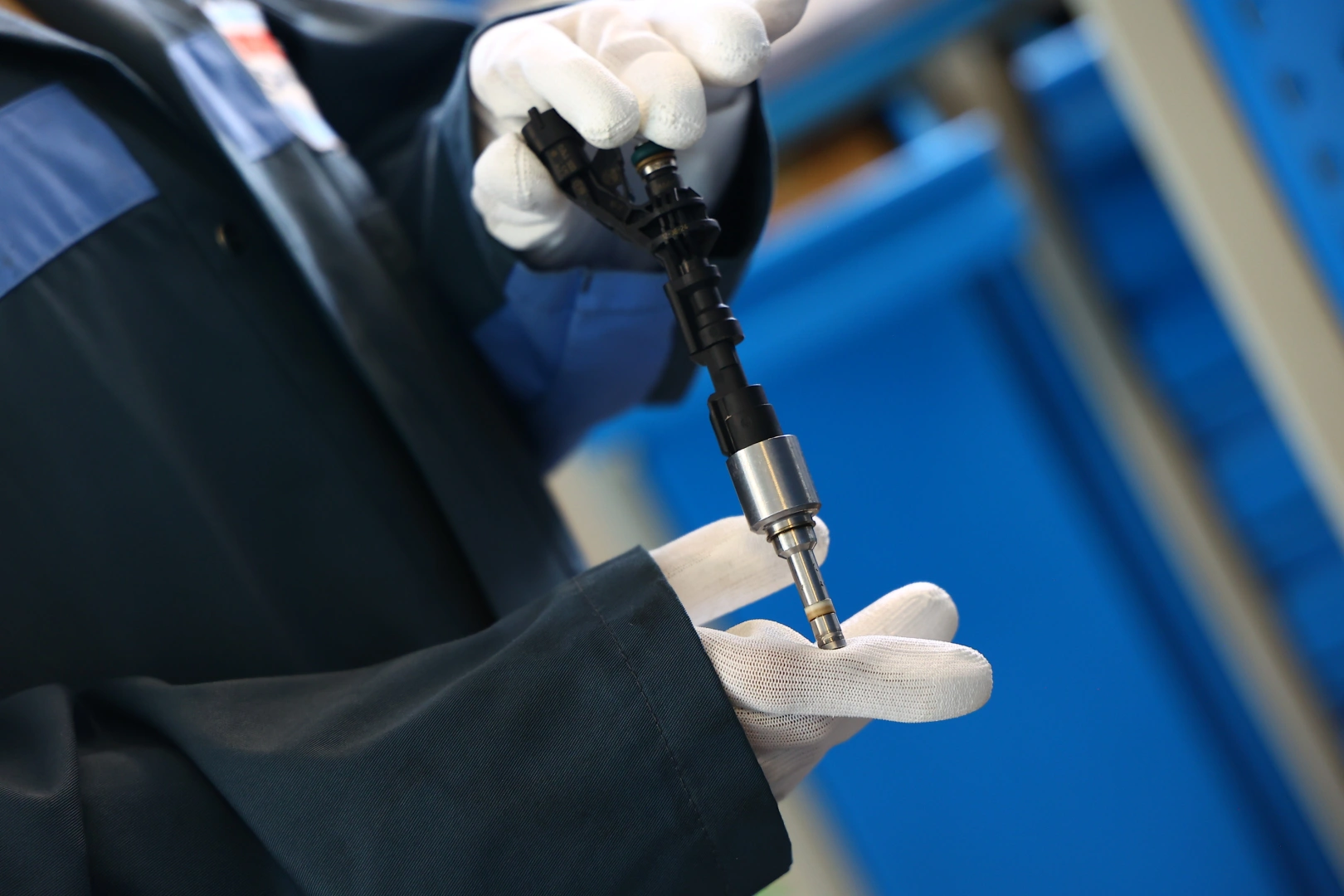 Wtryskiwacz benzynowy podczas kontroli technicznej Technik trzymający wtryskiwacz benzynowy podczas oględzin przed testem diagnostycznym