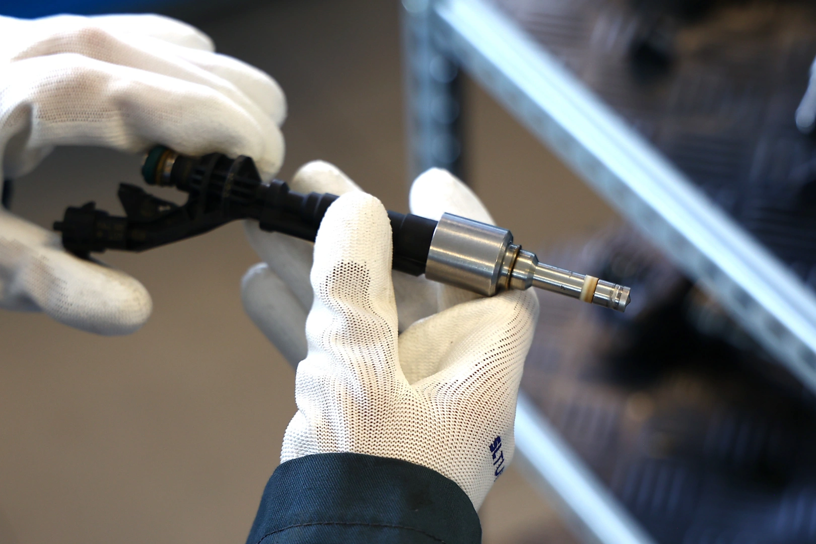 Technik trzymający wtryskiwacz benzynowy przed diagnostyką i kontrolą parametrów pracy