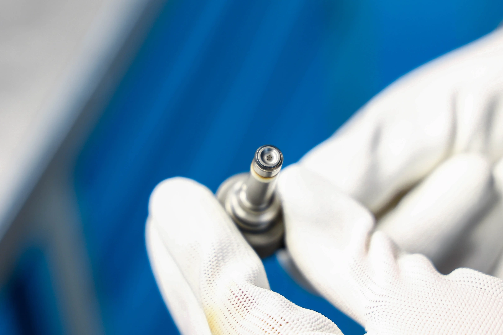 Zbliżenie końcówki rozpylacza wtryskiwacza benzynowego podczas kontroli otworów wylotowych i stanu części roboczej Zbliżenie końcówki rozpylacza wtryskiwacza benzynowego podczas kontroli otworów wylotowych i stanu części roboczej