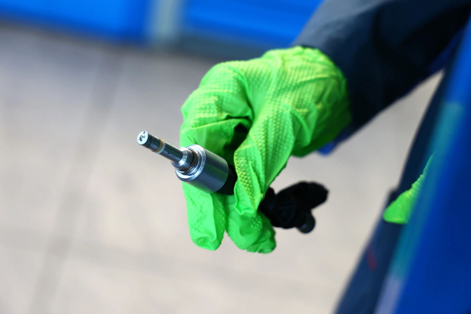 Zbliżenie na końcówkę wtryskiwacza trzymaną w dłoni mechanika Zbliżenie na końcówkę wtryskiwacza trzymaną w dłoni mechanika