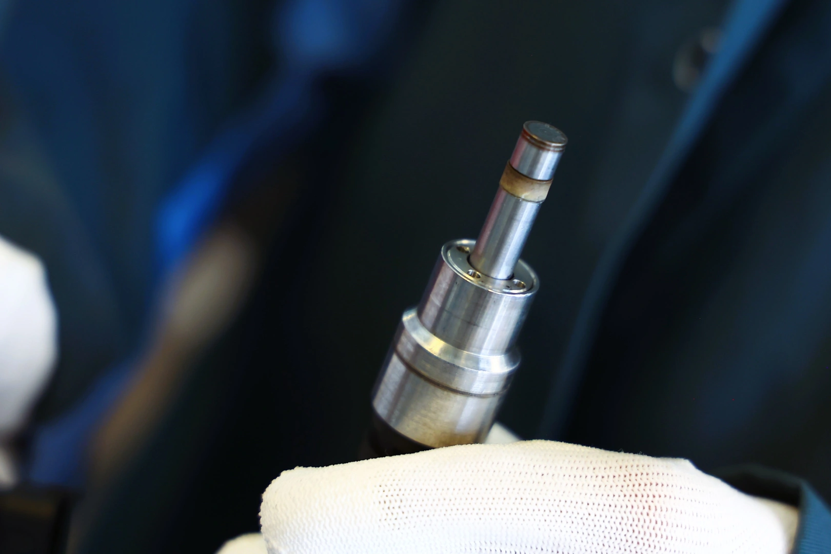 Zbliżenie na metalową końcówkę wtryskiwacza benzynowego sprawdzanego podczas oględzin technicznych. Zbliżenie na metalową końcówkę wtryskiwacza benzynowego sprawdzanego podczas oględzin technicznych.