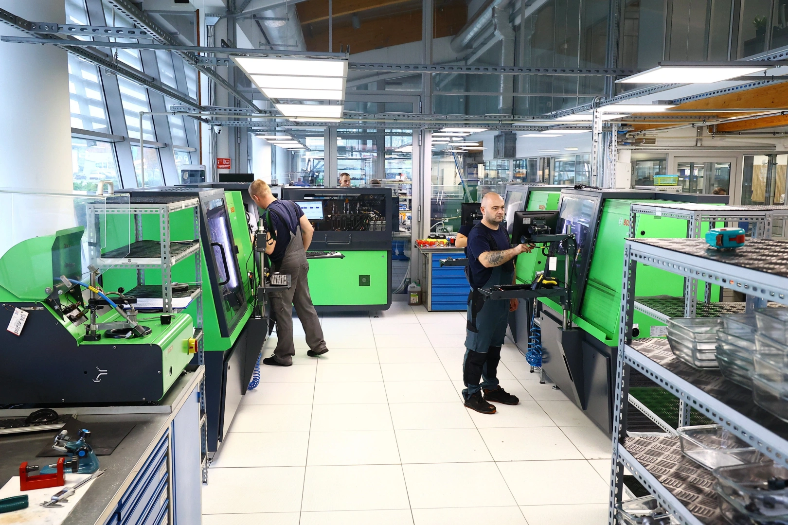 Rzeczywiste zaplecze technologiczne Pawlik Diesel Service. Fotografia przedstawia część pracowni specjalizującą się w diagnostyce i regeneracji aparatury wtryskowej silników Diesla, z licznymi stanowiskami probierczymi i zespołem podczas pracy.